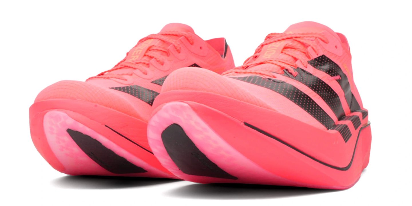 Pair of Adidas Adizero Adios Pro 5 running shoes in coral pink with black three-stripe detailing, rear studio view