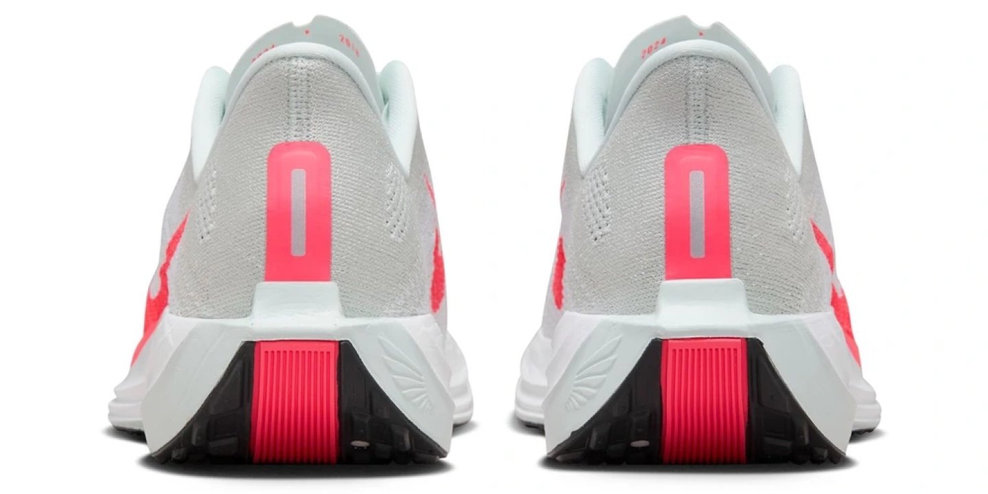 Rear view of two Nike Pegasus Plus running shoes showing grey engineered mesh upper, hot coral Swoosh, and white midsole with coral heel plug