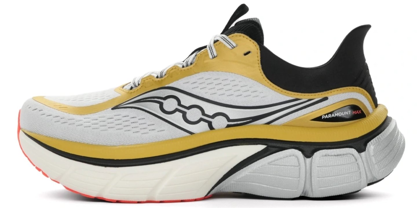Saucony Paramount Max running shoe in white, gold, and black with a chunky midsole, shown from the lateral side.