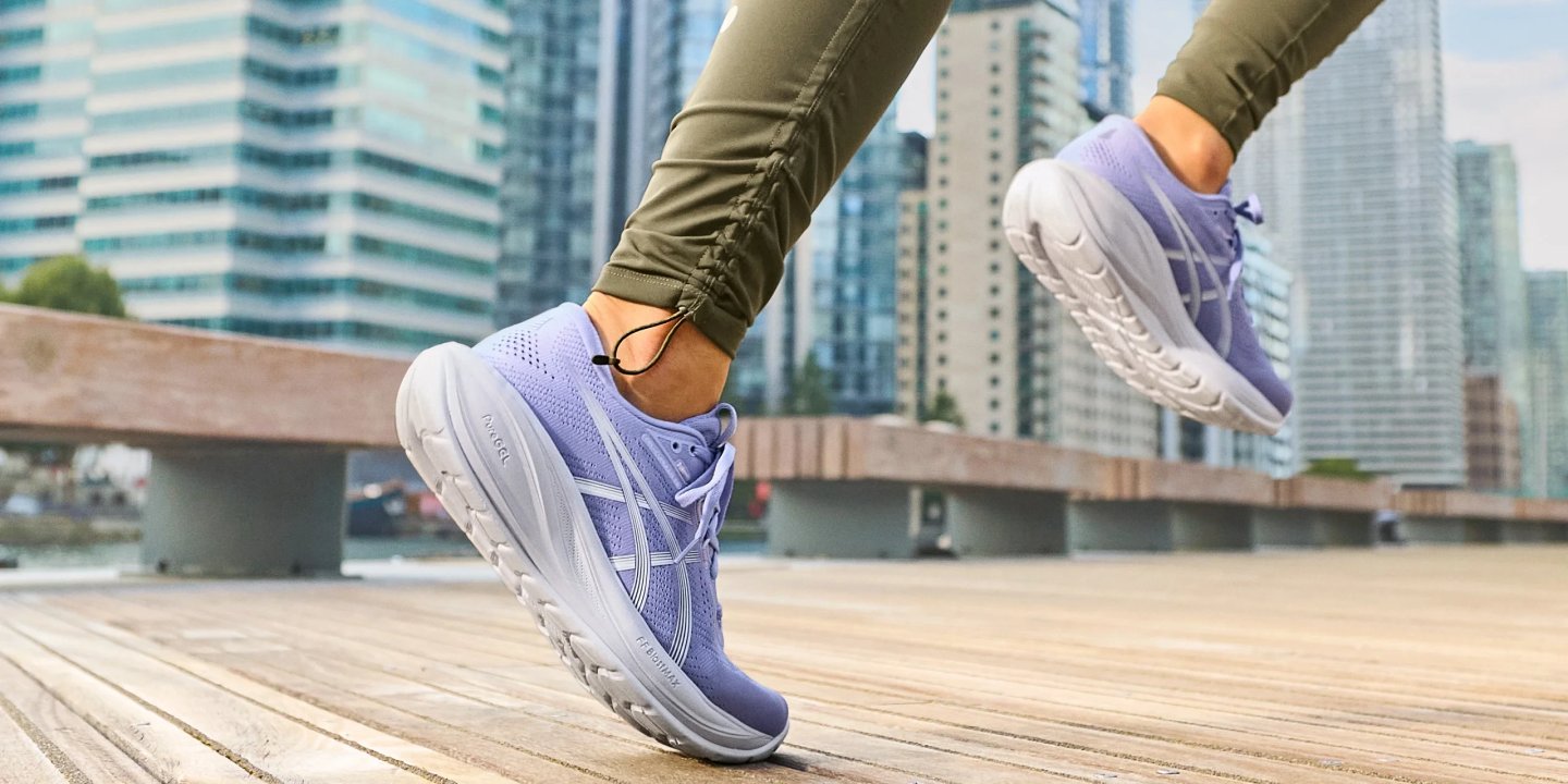 Women running in ASICS Gel-Nimbus lavender purple running shoes with thick FF Blast MAX midsole on urban boardwalk