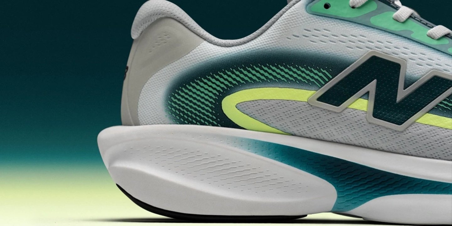 Close-up of New Balance running shoe with white foam midsole, teal outsole, mint green mesh upper.