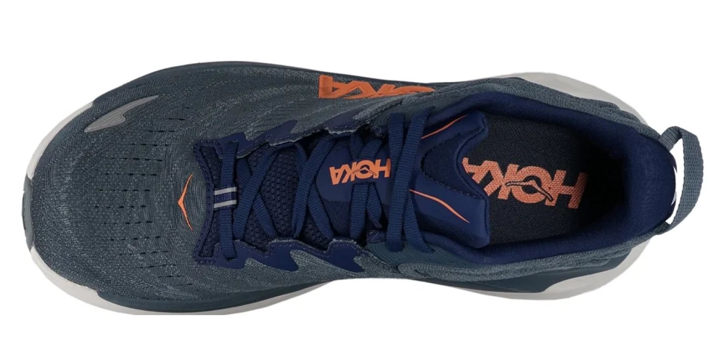 Top-down view of a HOKA running shoe in navy blue and grey with orange branding on the tongue and collar.