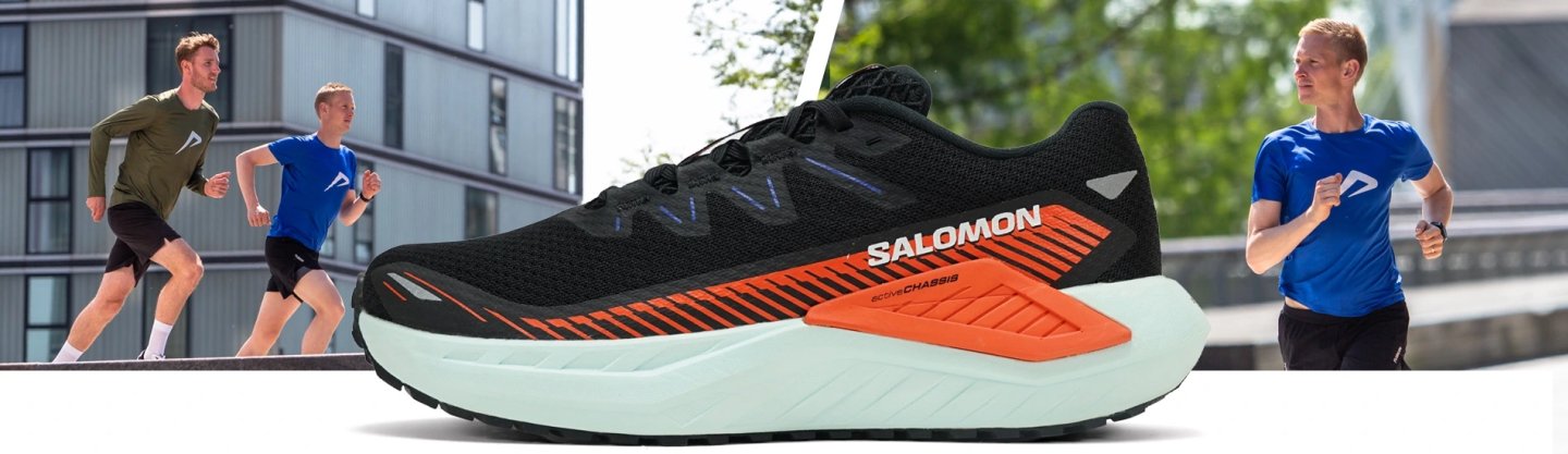 Salomon men's trail running shoe in black and orange with white Active Chassis midsole, shown with two male runners outdoors