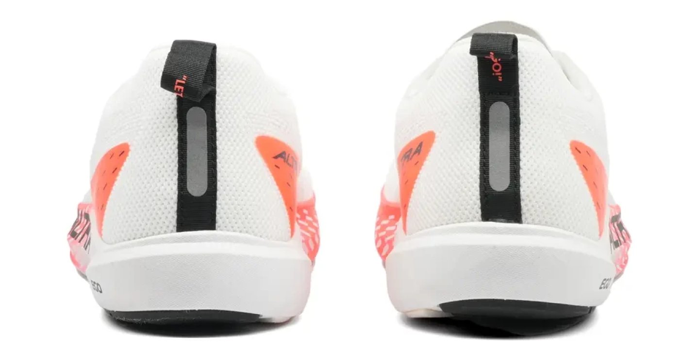 Rear view of a pair of Altra Vanish Pulse running shoes in white with coral orange accents and black pull tabs