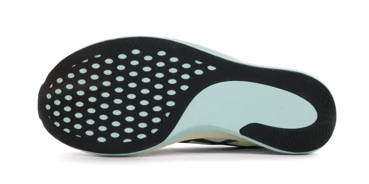 Bottom view of Asics running shoe outsole with circular perforated rubber pod in black and mint green heel section