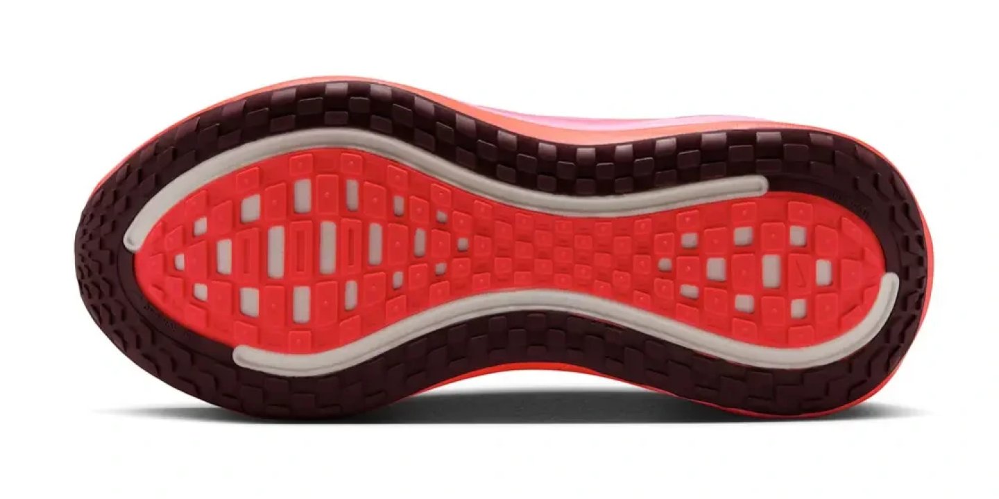 Bottom view of Nike running shoe outsole with bright red centre traction grid and dark purple outer lug pattern