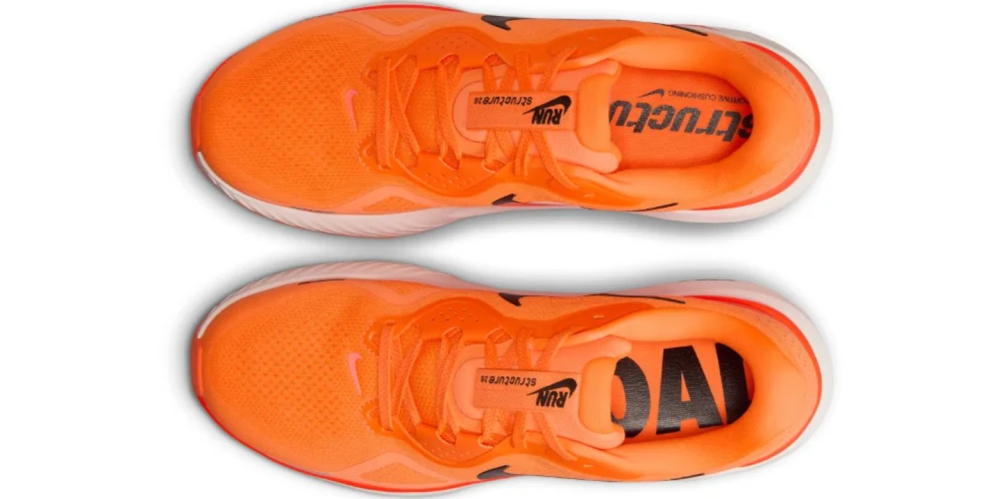 Top-down view of Nike Structure 25 running shoes in orange with black Swoosh logos and branded insoles.