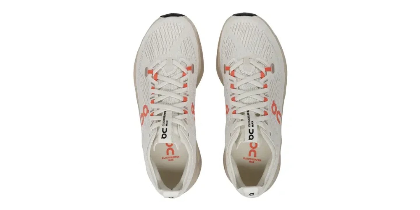 Top-down view of a pair of On Cloudsurfer Max running shoes in white with flame orange logo accents