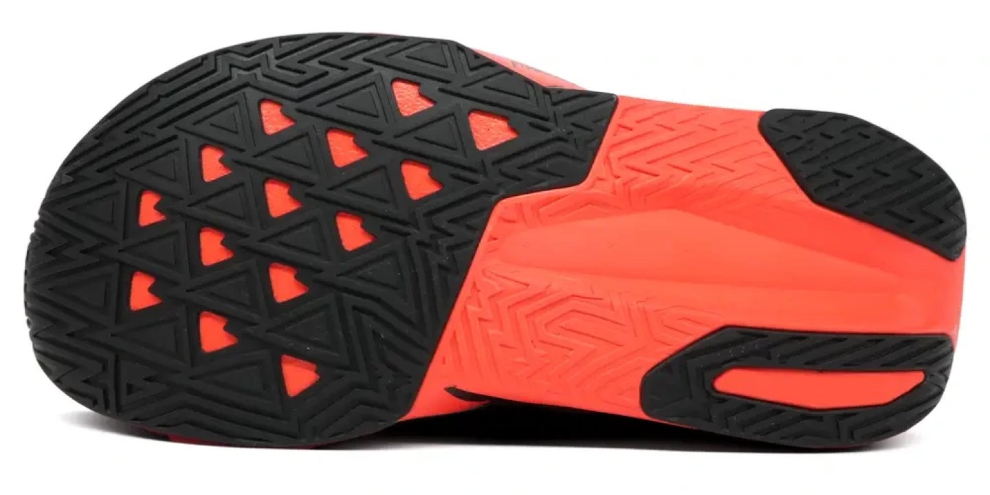 Bottom view of running shoe outsole with black rubber triangle tread pattern over vivid red midsole base