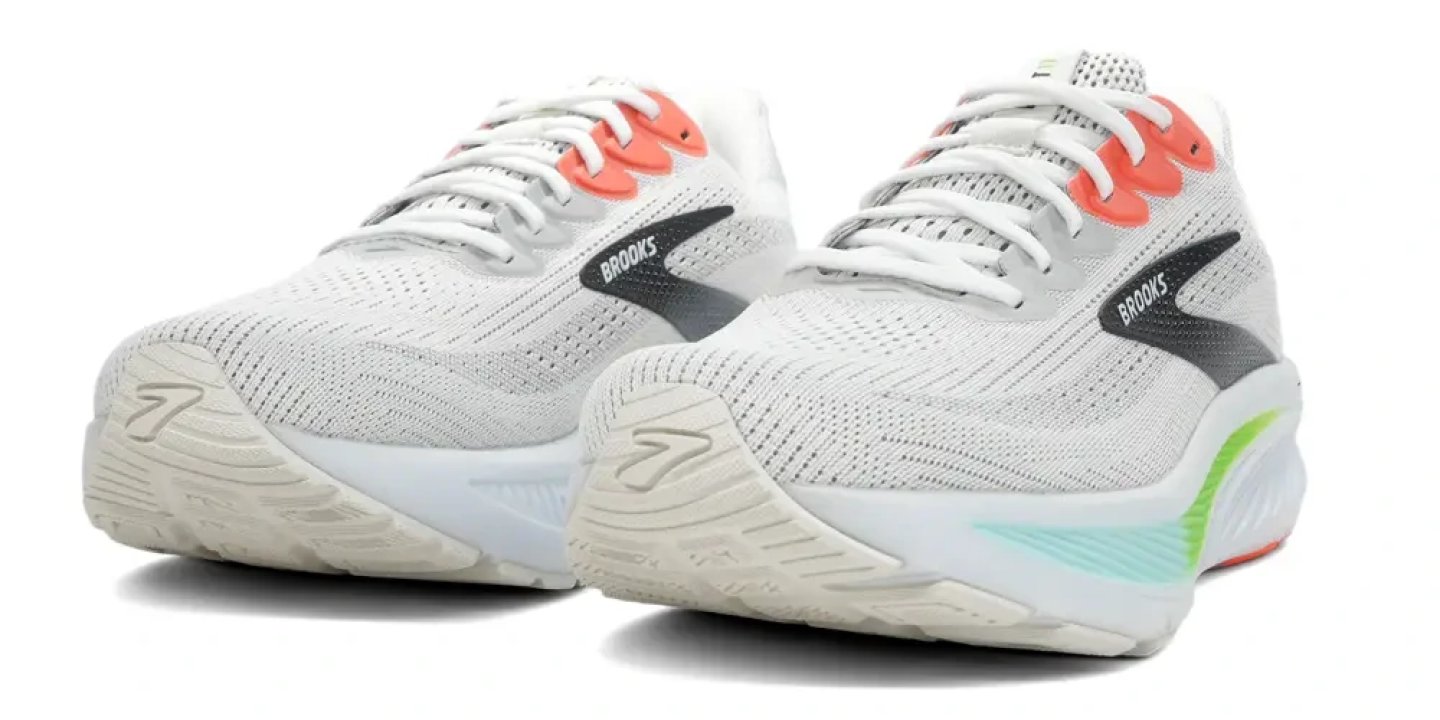 Pair of Brooks Ghost 17 running shoes in white with coral lace loops, green heel accent and grey knit upper