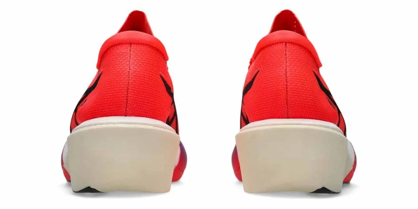 Rear view of a pair of Nike running shoes in crimson red with black Swoosh branding and a cream midsole.